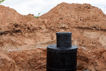 Canvas Print - Manhole, cesspool, concrete structure, circular ring blocks, pipeline repair, black tar waterproofing in the well, road works.