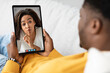 © Prostock-studio - African american man using digital tablet, calling girlfriend