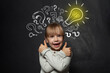 © millaf - Child girl school student with yellow lightbulb. Kid ideas and development concept