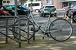Ein graues Fahrrad steht angeschlossen an einem Fahrradständer in der Stadt