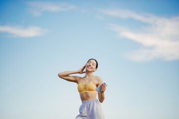 Cute girl with phone training on a sky backgroung