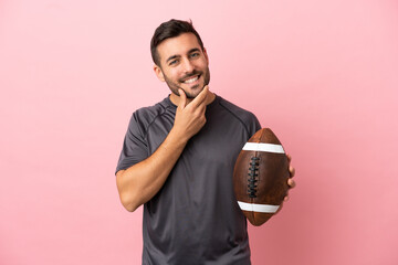 Wall Mural - Young caucasian man playing rugby isolated on pink background happy and smiling