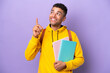 © luismolinero - Young student Brazilian man isolated on purple background pointing up a great idea