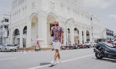 A young man travels with a backpack along the street of an asian city