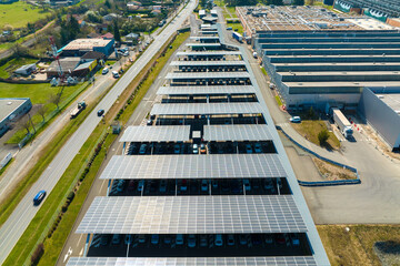 Aerial view of solar panels installed over parking lot with parked cars for effective generation of clean energy