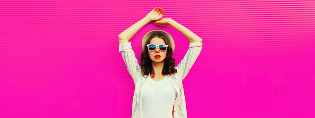 Portrait of young woman model posing wearing summer straw round hat on pink background, blank copy space for advertising text