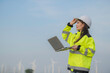 © reewungjunerr - women engineer working and holding the report at wind turbine farm Power Generator Station on mountain,Thailand people