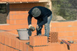 Builder applies cement for laying bricks on the wall. Bricklaying. Bricklayer builder, private master. Construction of a cottage, a country house.