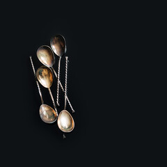 silver vintage spoons on black background