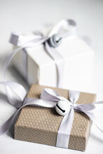 Two Gift Boxes On A Table Wrapped With Ribbons And Bells