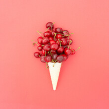 Red Cherry Fruits On An Ice Cream Cone On A Red Background. Minimal Summer Fruity Concept. Monochromatic Colors.