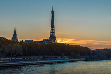 Paris, France - May 15, 2020: View of Seine river with Eiffel tower in background at sunset, in Paris