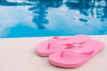 Pink Flip Flops For Swimming Pool Or Beach. Swimming Pool Water Texture. Pool Background With Summer Objects. To Use Text.