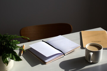 Wall Mural - Elegant home office desk table. Feminine workspace with paper notebook, cup of coffee, plant, chair.