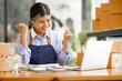 © David - Young Asian entrepreneur SME woman checking product on stock take note with a laptop. Small business owner working at home. Check address on the parcel SME online start up freelance concept.