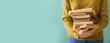 © Pixel-Shot - Young woman holding many books on color background with space for text