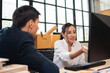 © winnievinzence - Asian female employee sitting and presenting project on computer to customer or manager in the office. active woman explaining work, corporate team working together