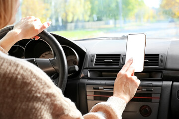 Wall Mural - Woman using smartphone for navigation while driving car