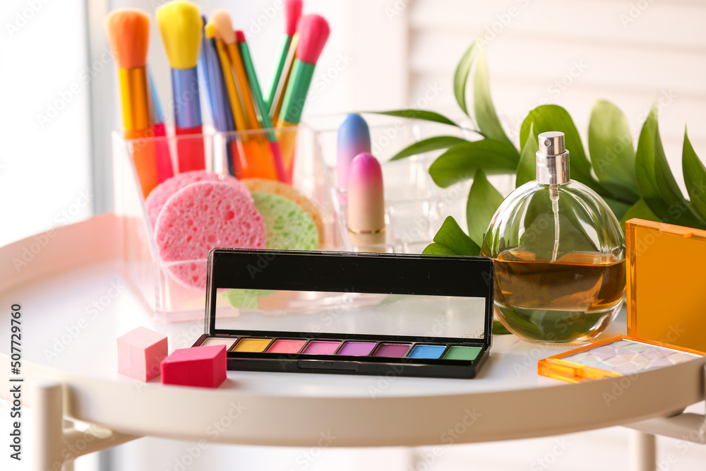 Cosmetic products with plant branch on table in room