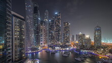 Panorama Showing Dubai Marina Tallest Skyscrapers And Yachts In Harbor Aerial Night Timelapse.