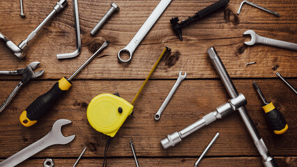 Flat lay with DYI composition of various work, carpentry tools knolled on brown wooden decks background pattern working table. Top view on new hand tool set for repair and construction kit, overhead