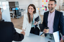 Smiling Businesswoman Standing Colleague Greeting Businessman In Office