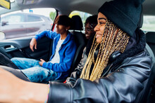Smiling Young Woman Sitting In Car With Friends