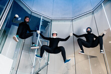 Athletes Holding Each Other Hands Flying In Wind Tunnel