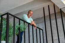 Man Leaning On Railing At Home