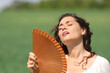 © Antonioguillem - Stressed woman suffering heat stroke in a field