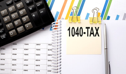 Poster - 1040 TAX text, written on a sticker with calculator,pen on chart background.