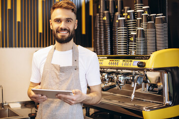 Male barista with tablet taking order in a coffee shop