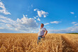 © Ryzhkov Oleksandr - Happy farmer proudly standing in wheat field. Agronomist wearing corporate uniform, looking at camera on farmland.