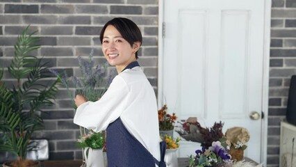 Leinwandbilder - 接客するエプロンをつけた女性　花屋　店員