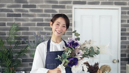 Fototapete - 花束を持つエプロンをつけた女性　花屋　店員