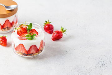 Canvas Print - Strawberry parfait with yogurt and granola in glass jar. Healthy breakfast recipe. Summer dessert concept.