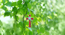 Christian Cross With Image Of A Dove On Birch Branches, Blurred Green Natural Background. Symbol Of Holy Spirit. Holy Trinity Sunday, Festive Pentecost Day. Faith In God, Church Holiday Concept