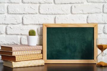 Poster - Books with picture frame on wooden table