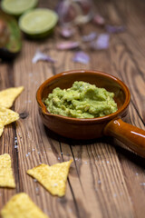 Wall Mural - avocado dip flavored with garlic, chili, pepper, and lime juice with corn nachos