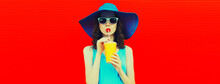 Portrait Of Beautiful Young Woman Drinking Fresh Juice From Cup Wearing Summer Hat On Red Background, Blank Copy Space For Advertising Text