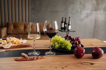 Assorted wine glasses with appetizers on wooden table