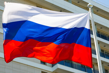 The flag of Russia is flying against the background of the building