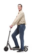 © ASDF - Side view of happy man rides a black kick scooter