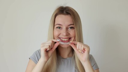 Wall Mural - Woman using clear removable braces, invisible teeth tray.