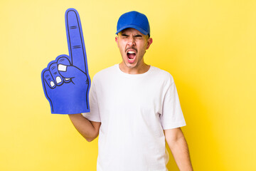 Wall Mural - young hispanic man shouting aggressively, looking very angry. number one fan concept