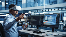 Industrial Software Developer Writing Code And Testing Automotive Manufacturing Interface. Engineer Editing Electric Motor And Car Chassis While Wearing Virtual Reality Headset And Using Controllers.