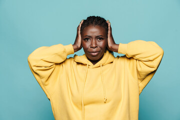 Wall Mural - Young black woman frowning while covering her ears