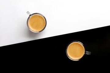 Two cups of coffee on black and white background. Espresso, arabica, ristretto in glass. Top view, copy space.