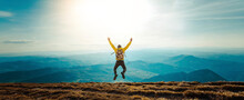 Happy Man With Open Arms Jumping On The Top Of Mountain - Hiker With Backpack Celebrating Success Outdoor - People, Success And Sport Concept