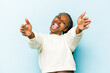 © Asier - Young african american woman isolated on blue background feels confident giving a hug to the camera.
